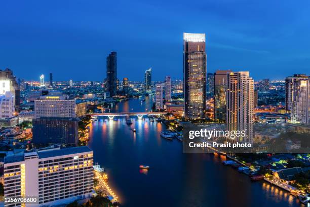 aerial view of bangkok skyline and skyscraper with light trails on chao phraya river and business in bangkok downtown, thailand. - bangkok hotel stock pictures, royalty-free photos & images