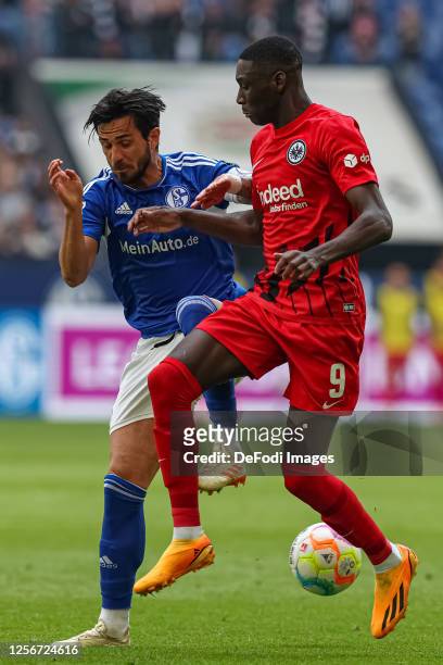 Danny Latza of FC Schalke 04 and Randal Kolo Muani of Eintracht Frankfurt battle for the ball during the Bundesliga match between FC Schalke 04 and...