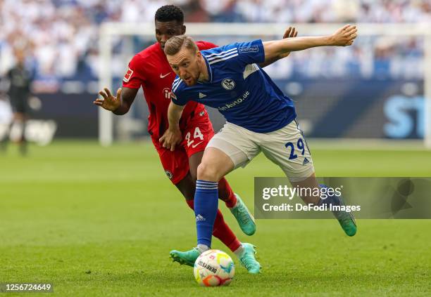 Tobias Mohr of FC Schalke 04 and Aurelio Buta of Eintracht Frankfurt battle for the ball during the Bundesliga match between FC Schalke 04 and...