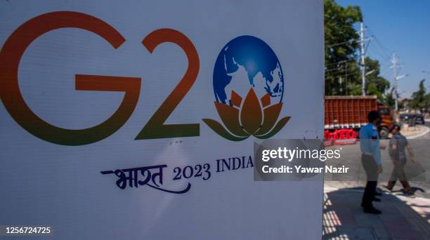 Indian policemen stand next to a sign erected on a road ahead of the G20 summit on May 21, 2023 in Srinagar, Indian administered Kashmir, India. The...