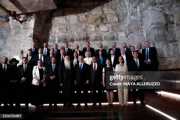 Israel's Prime Minister Benjamin Netanyahu poses with members of his cabinet ahead of the weekly meeting, inside the Western Wall tunnels in the Old...