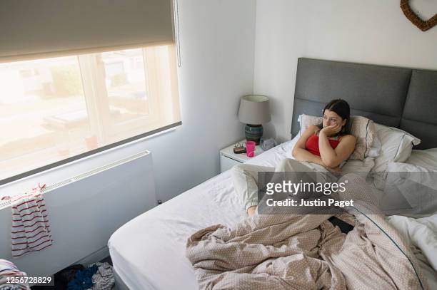 teenage girl sitting on bed - quarantine stock pictures, royalty-free photos & images