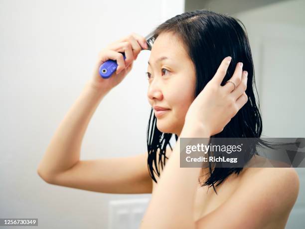 japanse vrouw die klaar in een badkamers wordt - woman brushing hair stockfoto's en -beelden
