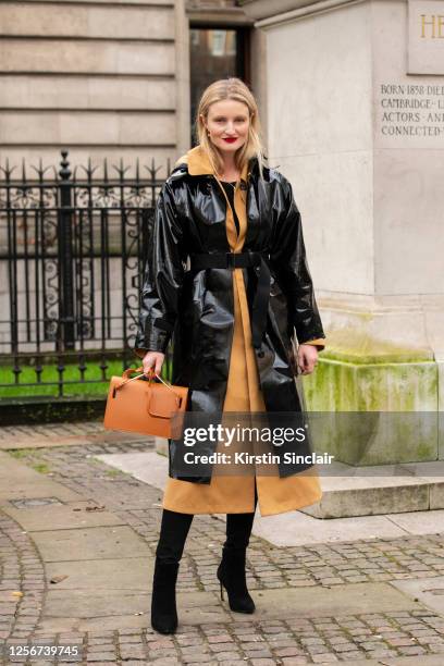 Photographer and model Candice Lake wears a Kassl Editions trench coat, Roksanda Ilincic bag and Jimmy Choo boots during London Fashion Week February...