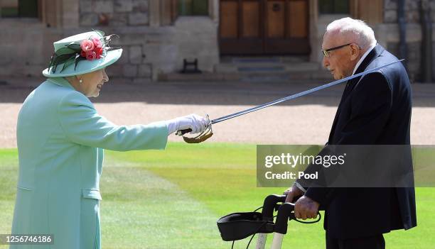 Queen Elizabeth II confers the Honour of Knighthood on Captain Sir Thomas Moore before presenting him with the insignia of Knight Bachelor during an...