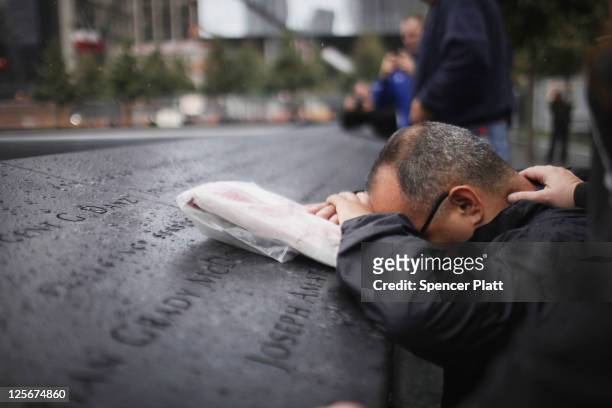Eddie Reyes is comforted while remembering fifteen of his colleagues in the New York Police Department Emergency Service Unit who were killed on...