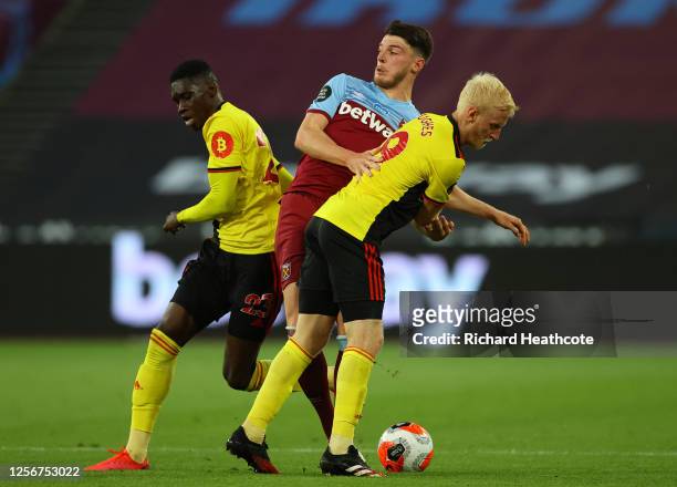 Ismaila Sarr of Watford and Will Hughes of Watford compete for the ball with Declan Rice of West Ham United during the Premier League match between...