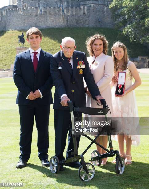 Captain Sir Thomas Moore poses with his family after receiving his Knighthood from Queen Elizabeth II during an investiture ceremony at Windsor...