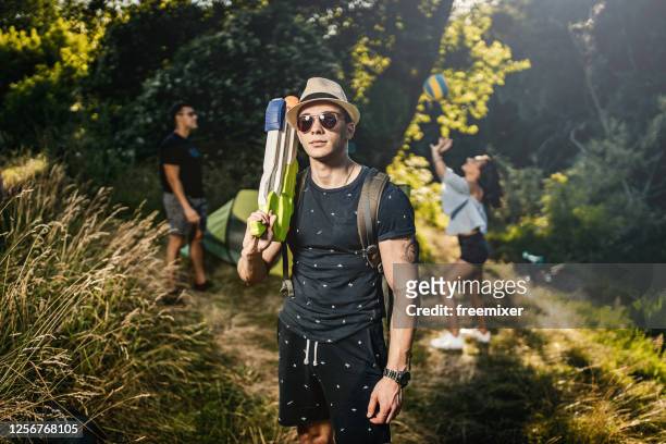young man holding squirt gun and posing outdoors - toy gun stock pictures, royalty-free photos & images