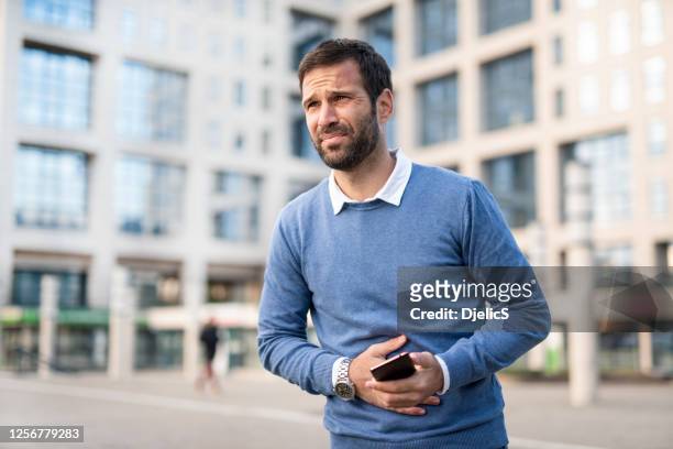 man in the city having stomachache. - stomach stock pictures, royalty-free photos & images