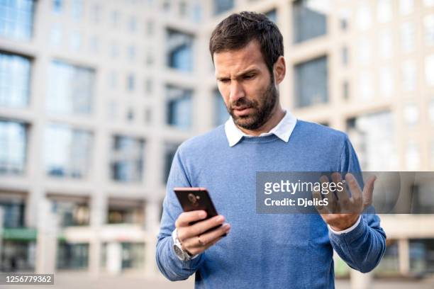 frustrierte mittlere erwachsene mann mit telefon. - frustrated on phone stock-fotos und bilder