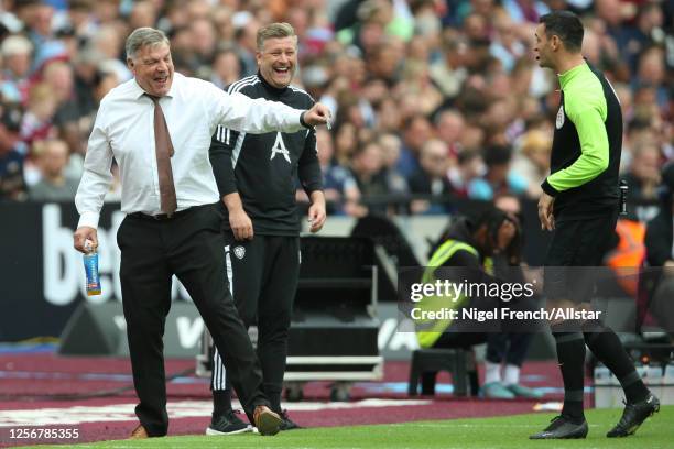 Sam Allardyce, Manager of Leeds United and Karl Robinson Assistant Manager of Leeds United shares a joke with match Official, during the Premier...