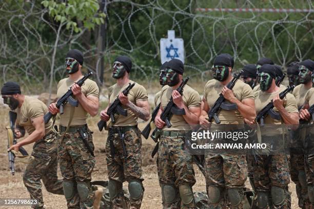 Lebanese Hezbollah fighters take part in cross-border raids, part of large-scale military exercise, in Aaramta bordering Israel on May 21, 2023 ahead...