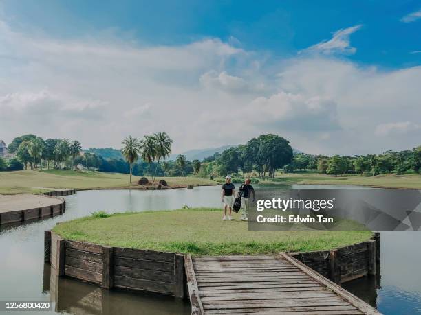 golfer die golf in golfcursus in melaka speelt, maleisië dat naar het dragen van golf reeks loopt - malaysia father and son stockfoto's en -beelden