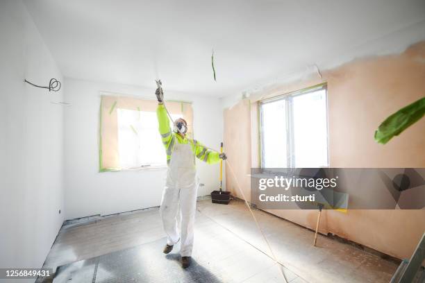 female painter using spray gun - spray paint stock pictures, royalty-free photos & images