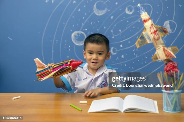 little boy reaching for rocket in drawn space. - tafel kind rakete stock-fotos und bilder