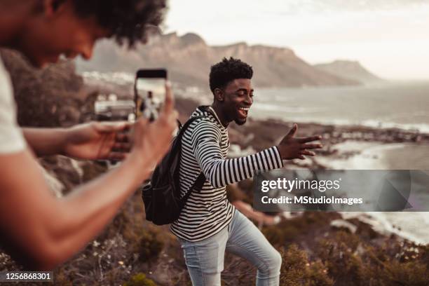 homme prenant une photo de son ami pendant qu’il danse - man wearing cap photos et images de collection