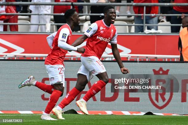 Reims' midfielder Marshall Munetsi and Reims' forward Folarin Balogun celebrate after scoring a goal during the French L1 football match between...