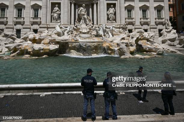 Police stands guard on May 21, 2023 at the Fontana di Trevi fountain in downtown Rome after environmental activists of Last Generation poured black...