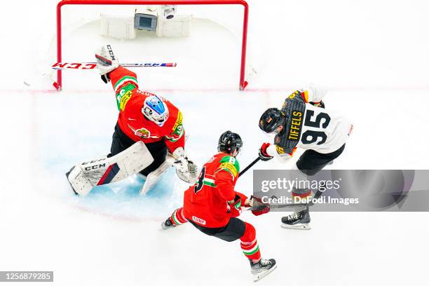 Bence Balisz of Hungary, Bence Szabo of Hungary and Frederik Tiffels of Germany battle for the ball during the 2023 IIHF Ice Hockey World...