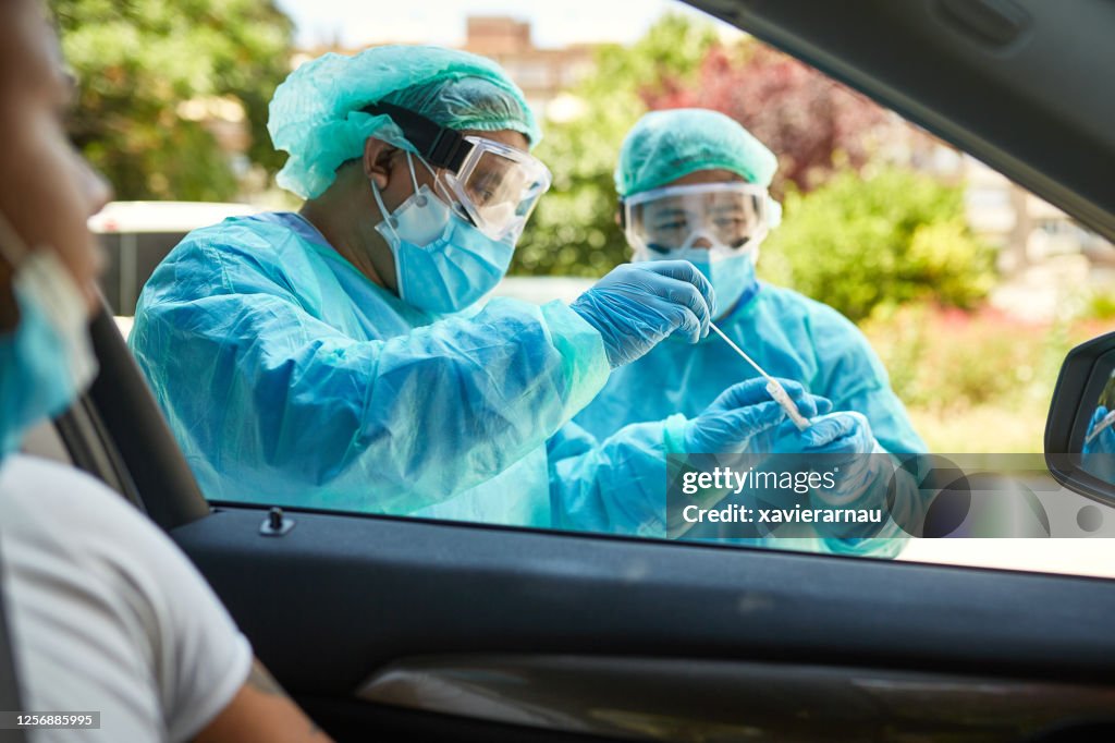 Healthcare Workers Placing Nasal Swab in Transport Medium
