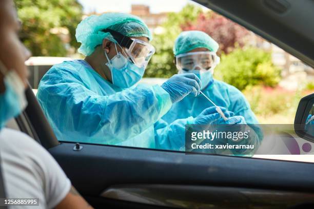Healthcare Workers Placing Nasal Swab in Transport Medium