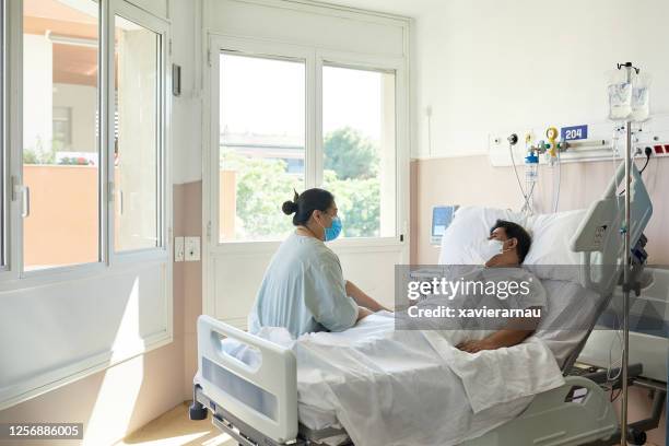 herstellende covid-19 patiënt en bezoeker in ziekenhuiskamer - person in emergency hospital stockfoto's en -beelden