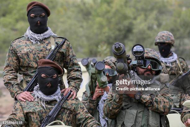 May 2023, Lebanon, Aramta: Pro-Iranian Hezbollah fighters take the oath during a staged military exercise in a camp in the Lebanese southern village...