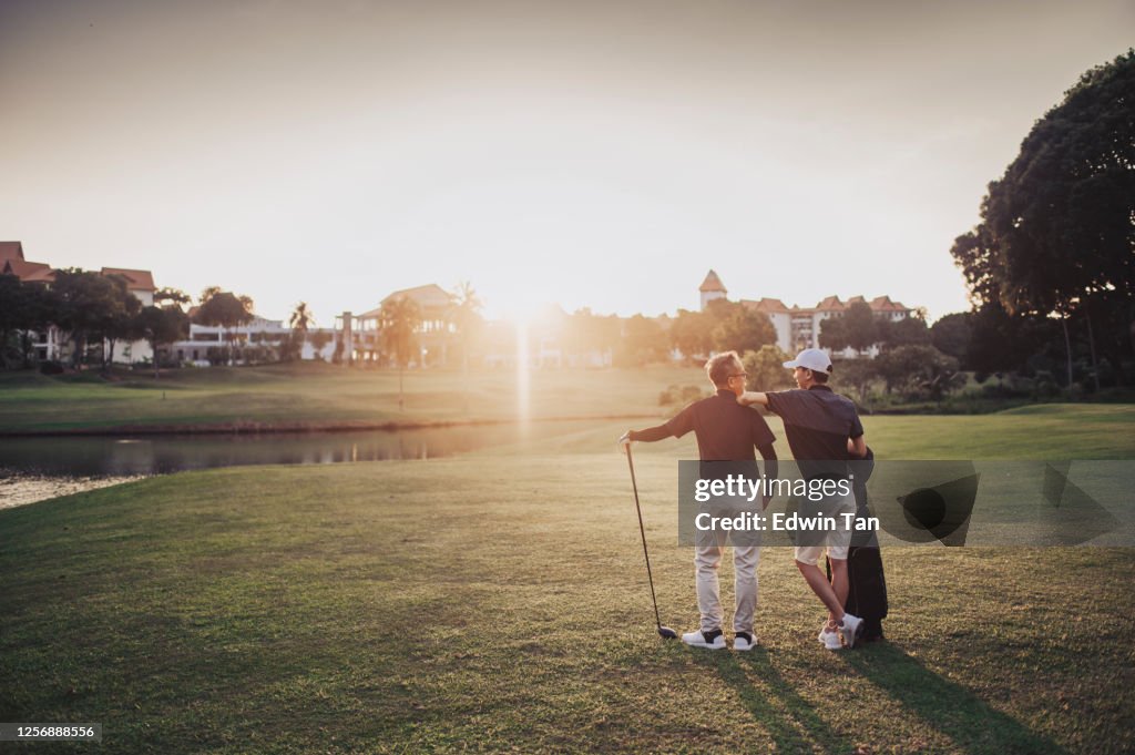 An asian chinese senior man golfer carrying his golf club on his shoulder and looking at the view in golf course