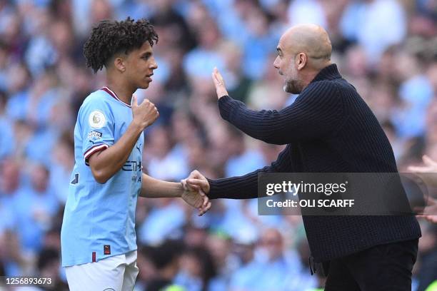 Manchester City's English defender Rico Lewis receives instructions from Manchester City's Spanish manager Pep Guardiola during the English Premier...