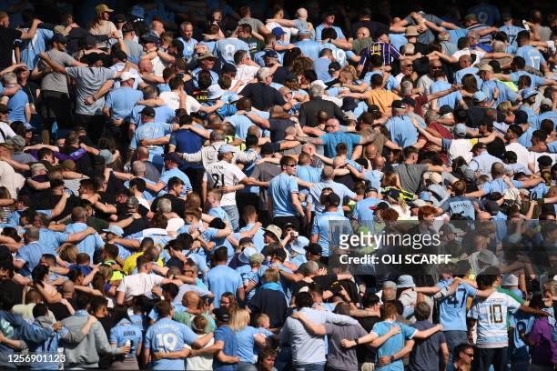 Manchester City fans do 'the Poznan' celebration during the English Premier League football match between Manchester City and Chelsea at the Etihad...