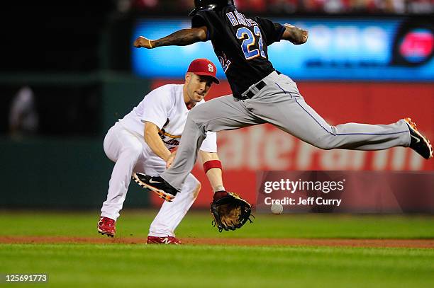 Skip Schumaker of the St. Louis Cardinals fields a ground ball as Willie Harris of the New York Mets leaps over the ball at Busch Stadium on...