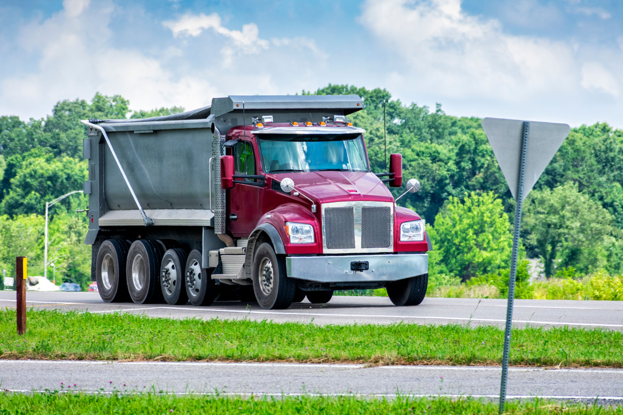 Large Dump Truck Delivering Gravel To Commercial Construction Site Large Dump Truck Delivering Gravel To Commercial Construction Site