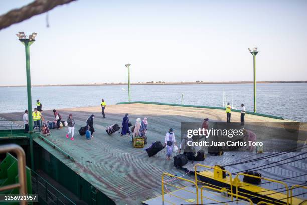 Some seasonal workers carry their luggage before boarding the ship back to Morocco at Palos de la Frontera port on July 18, 2020 in Palos de la...