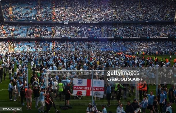 Manchester City fans invade the pitch as they celebrate winning the title after the English Premier League football match between Manchester City and...