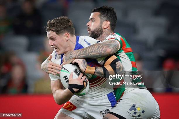 Kurt Mann of the Knights is tackled by Adam Reynolds of Souths during the round 10 NRL match between the South Sydney Rabbitohs and the Newcastle...