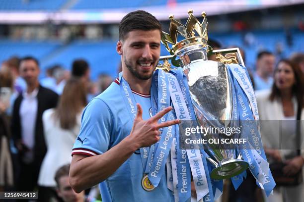 Manchester City's Portuguese defender Ruben Dias poses with the Premier League trophy after the presentation ceremony following the English Premier...