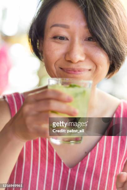 asian lady tasting caipirinha in copacabana rio de janeiro - caipirinha stock pictures, royalty-free photos & images