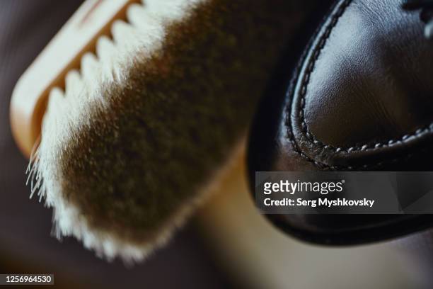 a close-up of a shoe brush near a black leather male shoe. - calzature di pelle foto e immagini stock