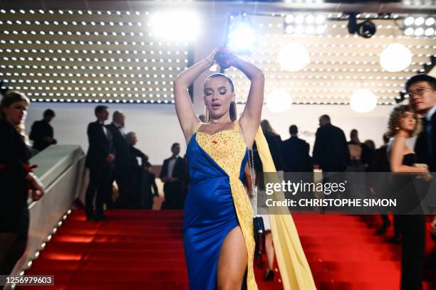 Ukrainian influencer Ilona Chernobai, wearing a dress in the colours of the Ukrainian flag, covers herself in fake blood on the stairs on the...