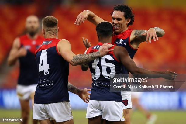 Kysaiah Pickett of the Demons celebrates with his team mates James Harmes and Harley Bennell of the Demons after kicking a goal during the round 7...