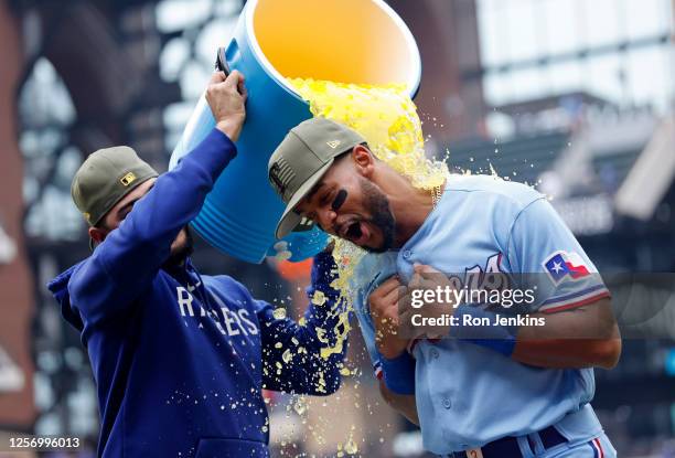 Martin Perez of the Texas Rangers pours Powerade on teammate Leody Taveras following the team's 13-3 win over the Colorado Rockies at Globe Life...