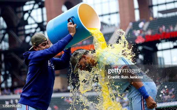 Martin Perez of the Texas Rangers pours Powerade on teammate Leody Taveras following the team's 13-3 win over the Colorado Rockies at Globe Life...