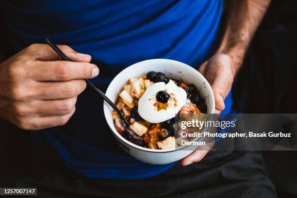 a man eating porridge - fiocchi di avena foto e immagini stock