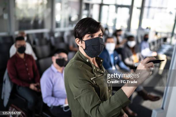 businesswoman speaking at a business conference - with face mask - organised group stock pictures, royalty-free photos & images