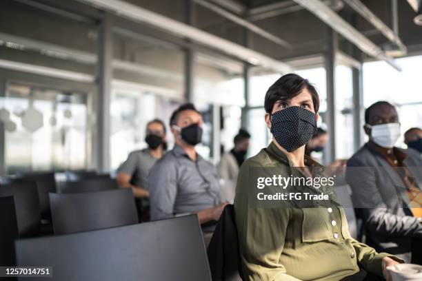 zakenmensen die een seminar met sociale het distantiëren en gezichtsmasker bijwonen - social distancing classroom stockfoto's en -beelden