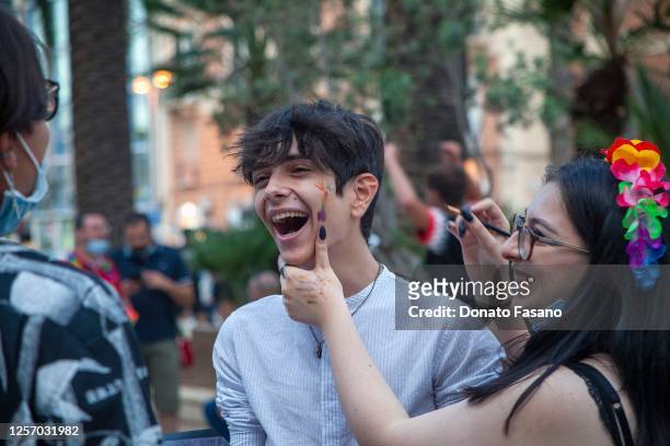 Girl paints the penis on the cheek of an amused friend in LGBT Pride Event In Bari on July 18, 2020 in Bari, Italy.