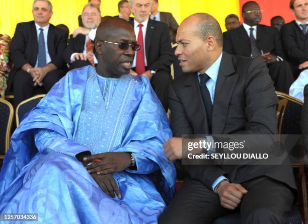 Senegalese Prime minister Souleymane Ndene Mbaye speaks with a minister of state Karim Wade on February 12 in Rufisque during the launch of the...