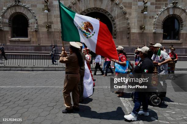 An organ grinder holds a Mexican flag in the streets of Mexico City during the First Festival of Organilleros in Mexico, on may 21 which included the...