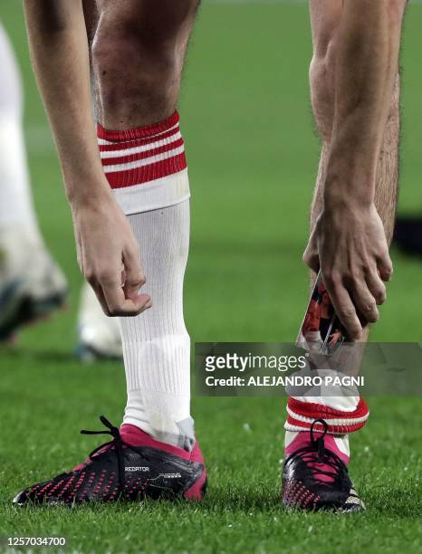 River Plate's midfielder Ignacio Fernandez takes his shin guard with an image of his family while celebrating after scoring against Platense during...